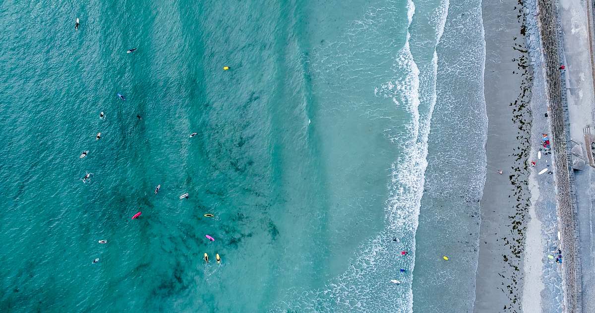 aerial view aerial photography of people on beach at daytime drone view